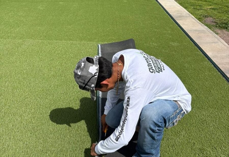 Instalador de Game Turf fijando el remate perimetral del pasto sintético durante una instalación residencial.