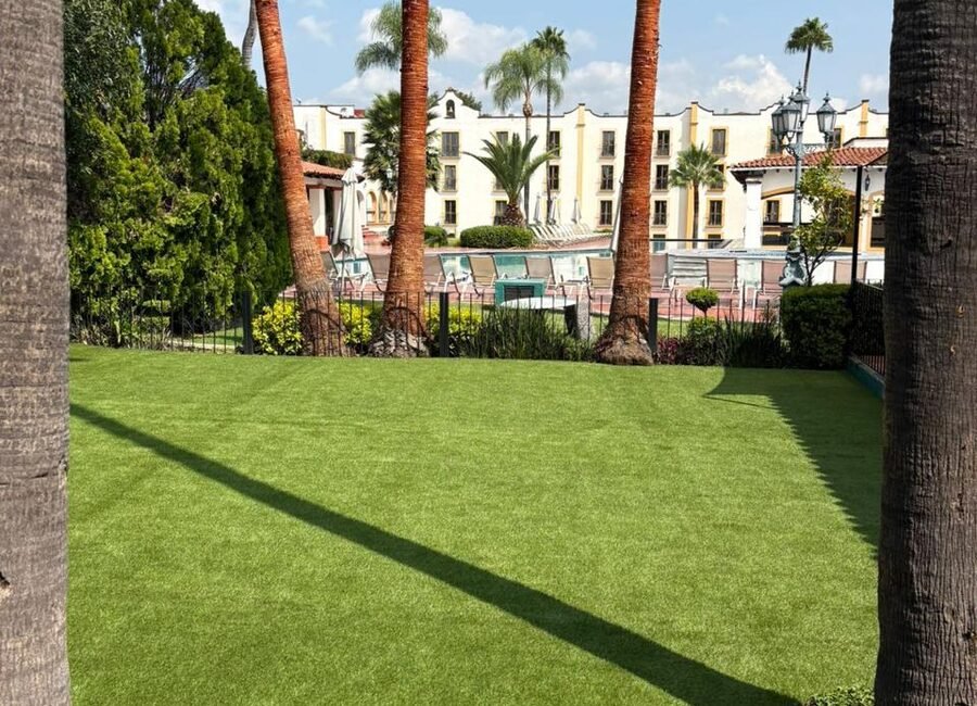 Pasto sintético Game Turf en el jardín contiguo a la alberca de un conjunto residencial.